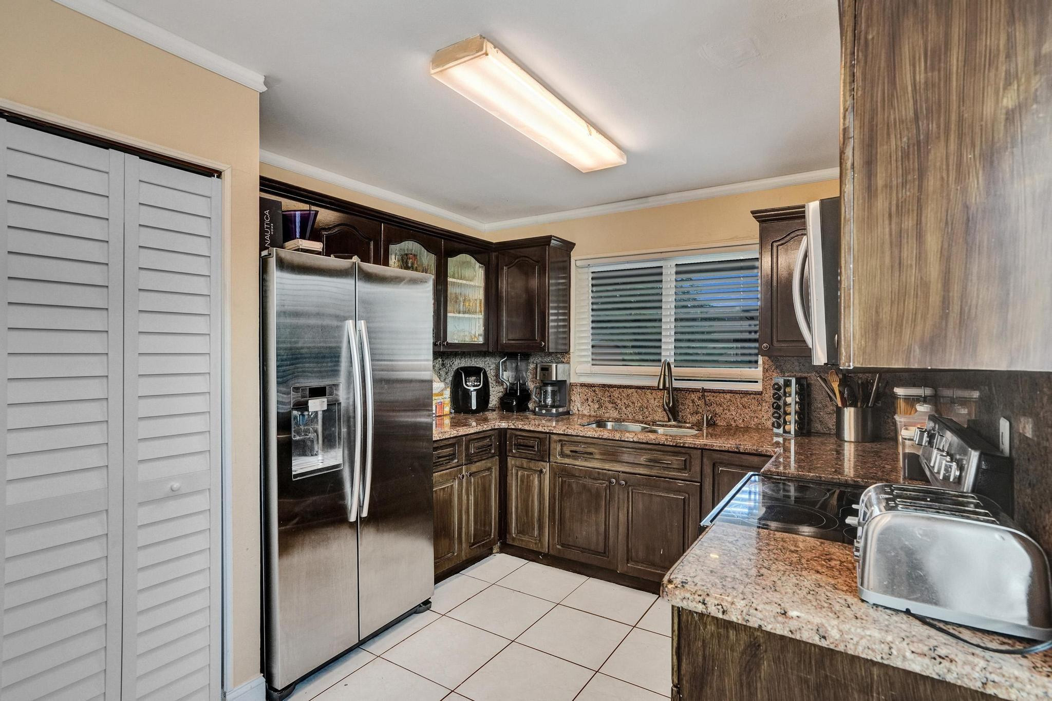 26205 Southwest 133rd Court Homestead, FL 33032 - Photo 23 of 45 a kitchen with granite countertop a sink stainless steel appliances and cabinets