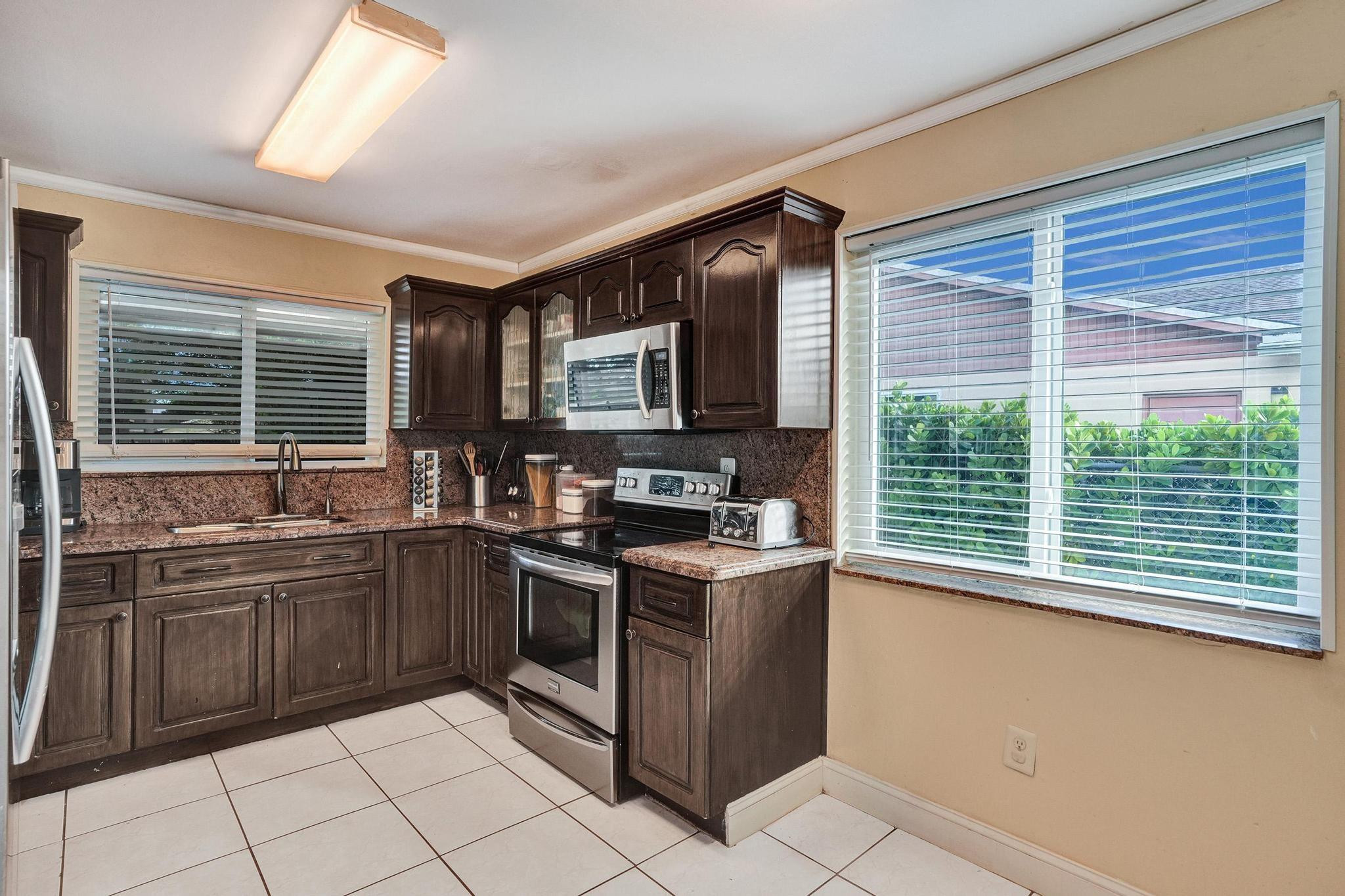 26205 Southwest 133rd Court Homestead, FL 33032 - Photo 24 of 45 a kitchen with stainless steel appliances granite countertop a sink stove and cabinets
