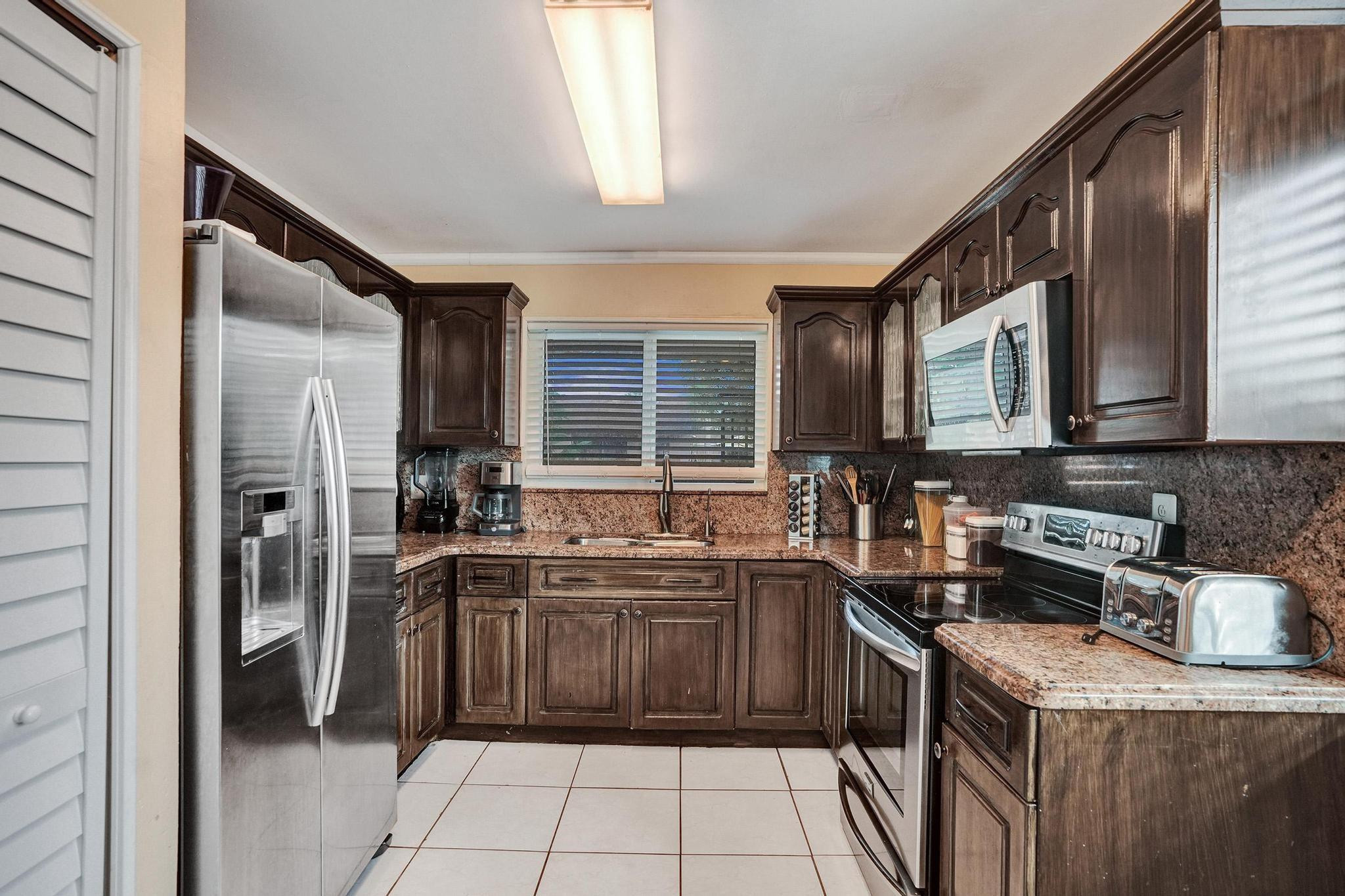 26205 Southwest 133rd Court Homestead, FL 33032 - Photo 25 of 45 a kitchen with stainless steel appliances granite countertop a sink stove and refrigerator