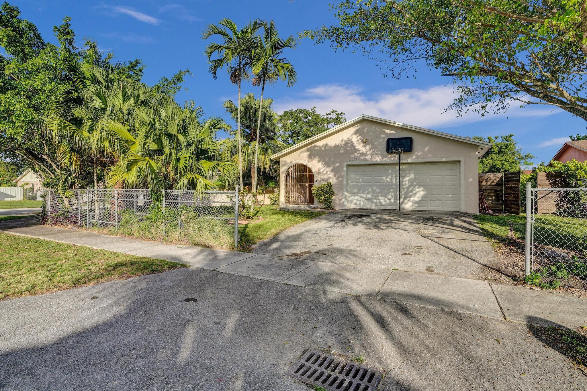 26205 Southwest 133rd Court Homestead, FL 33032 - Photo 3 of 45 a front view of a house with a yard