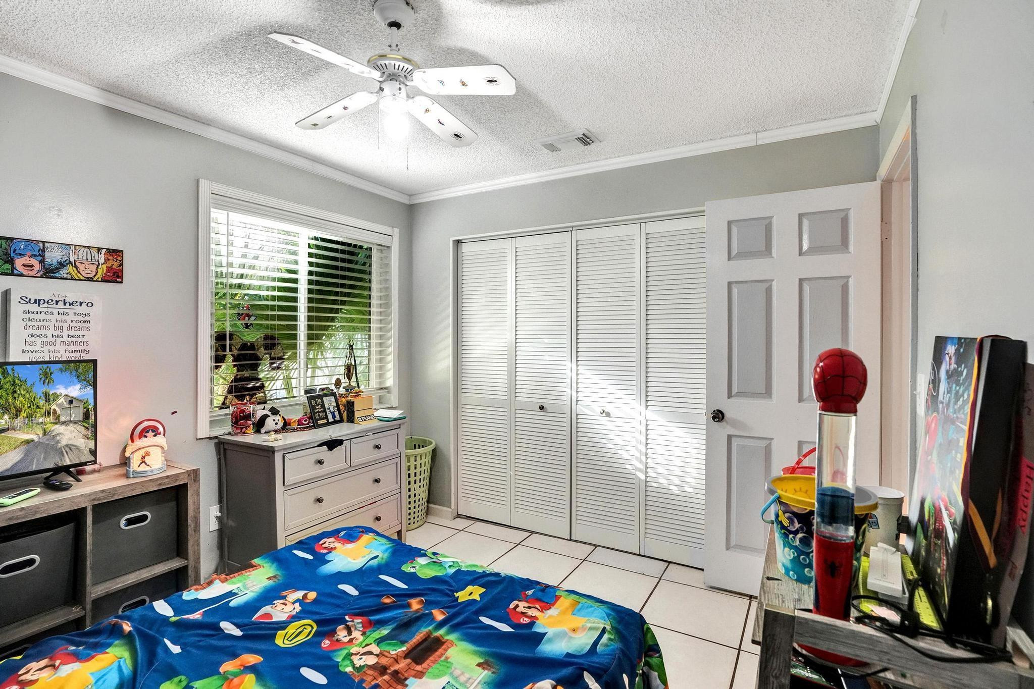 26205 Southwest 133rd Court Homestead, FL 33032 - Photo 31 of 45 a bedroom with furniture a flat screen tv and a window