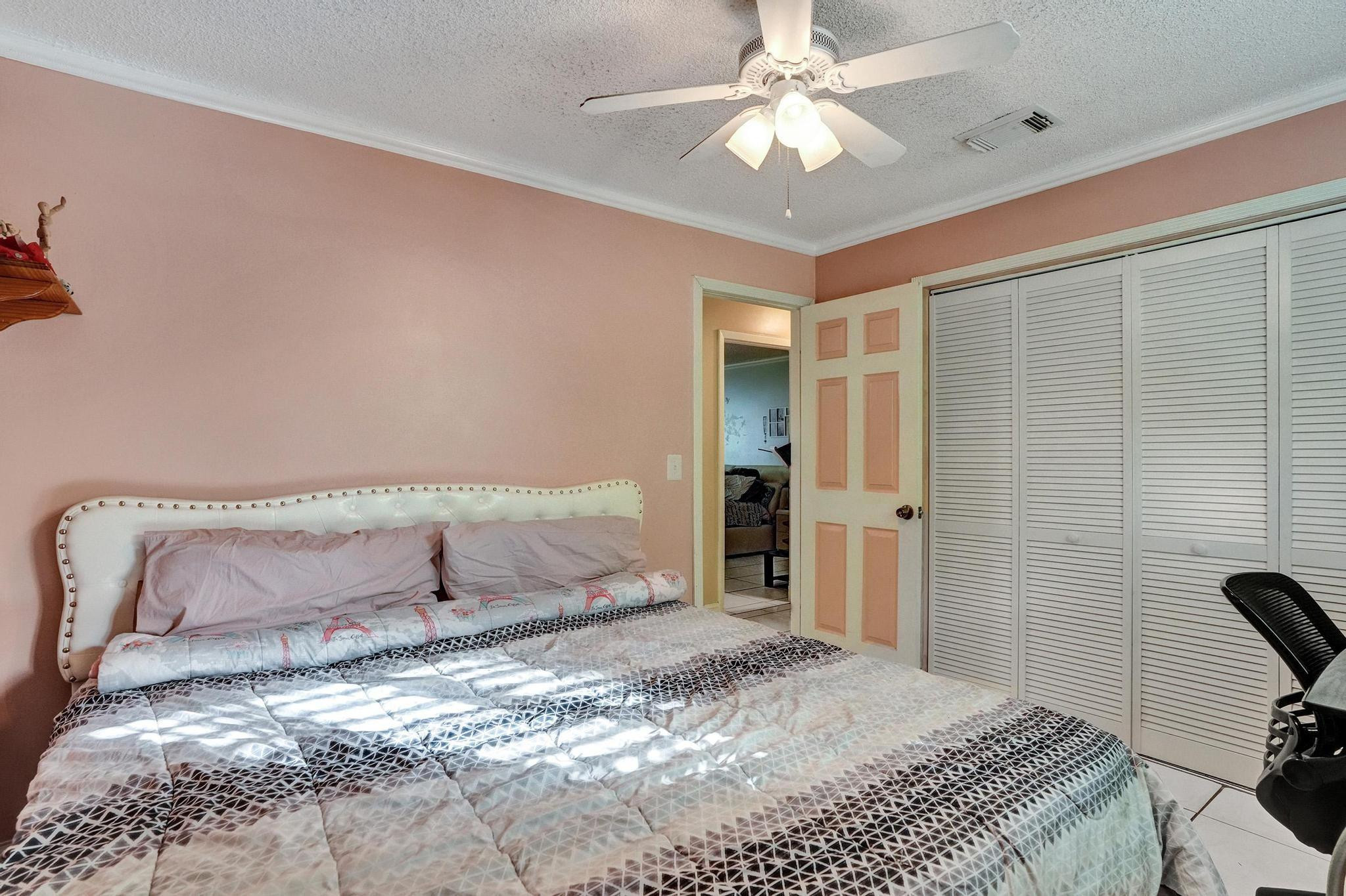 26205 Southwest 133rd Court Homestead, FL 33032 - Photo 43 of 45 a bedroom with a bed and a chandelier