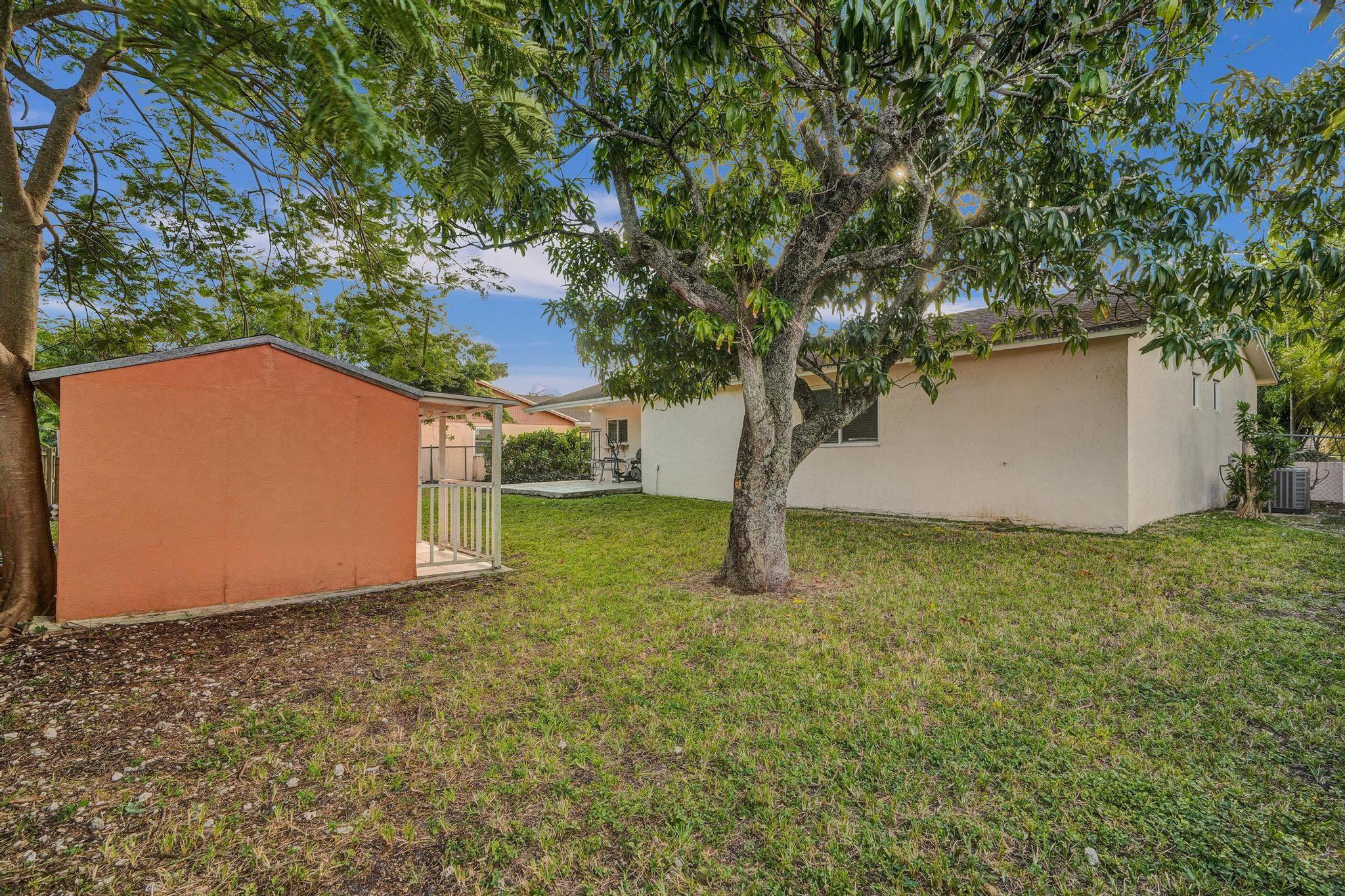 26205 Southwest 133rd Court Homestead, FL 33032 - Photo 8 of 45 a backyard of a house with plants and large tree