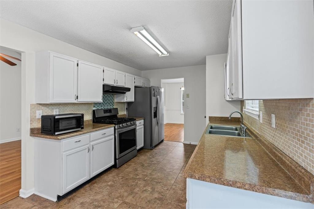 2242 Rocksram Court Buford, GA 30519 - Photo 16 of 52 a kitchen with granite countertop a stove sink and refrigerator
