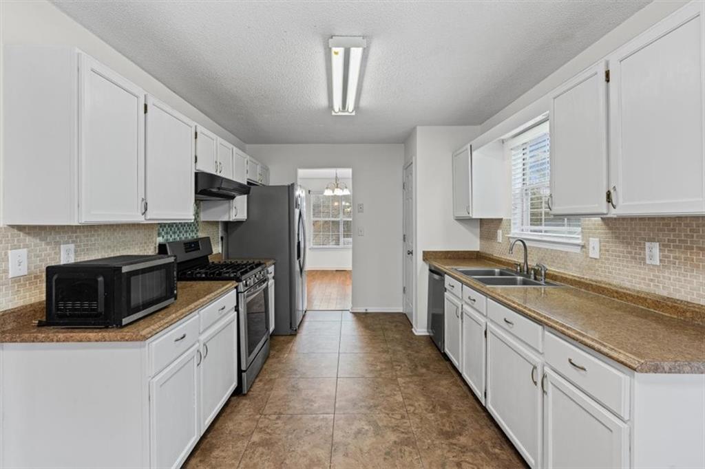 2242 Rocksram Court Buford, GA 30519 - Photo 17 of 52 a large kitchen with stainless steel appliances granite countertop a stove a sink and a refrigerator
