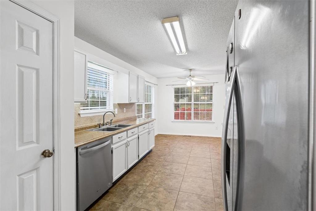 2242 Rocksram Court Buford, GA 30519 - Photo 19 of 52 a kitchen with stainless steel appliances granite countertop a sink and a refrigerator
