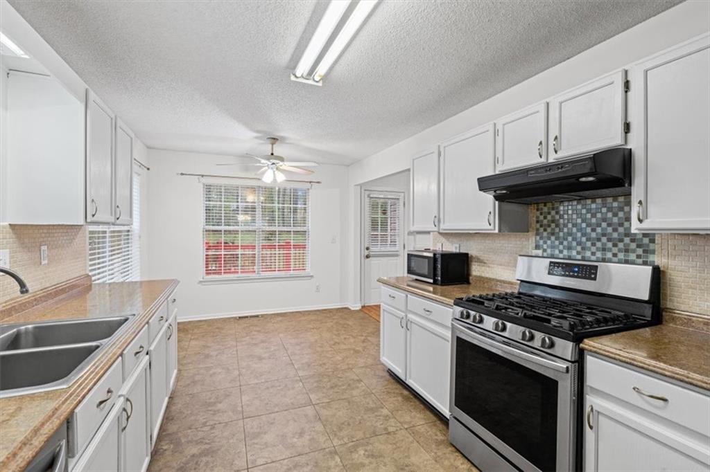 2242 Rocksram Court Buford, GA 30519 - Photo 21 of 52 a kitchen with stainless steel appliances a stove a sink and a microwave