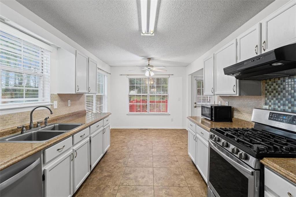 2242 Rocksram Court Buford, GA 30519 - Photo 22 of 52 a kitchen with granite countertop a sink stove and cabinets