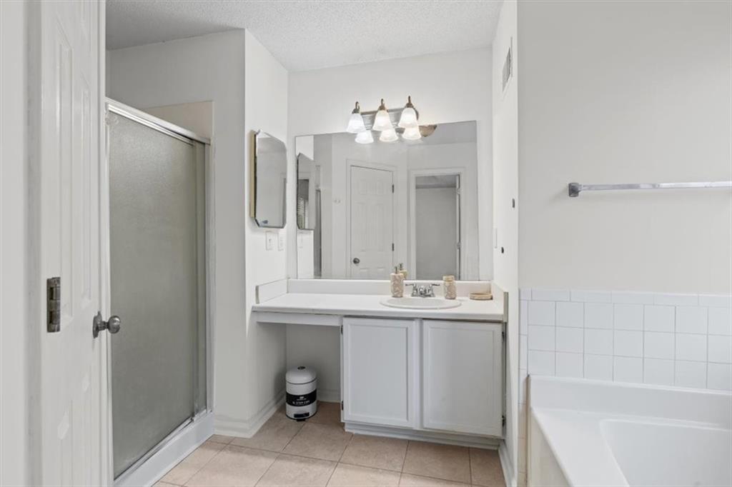 2242 Rocksram Court Buford, GA 30519 - Photo 29 of 52 a bathroom with a double vanity sink mirror and bathtub