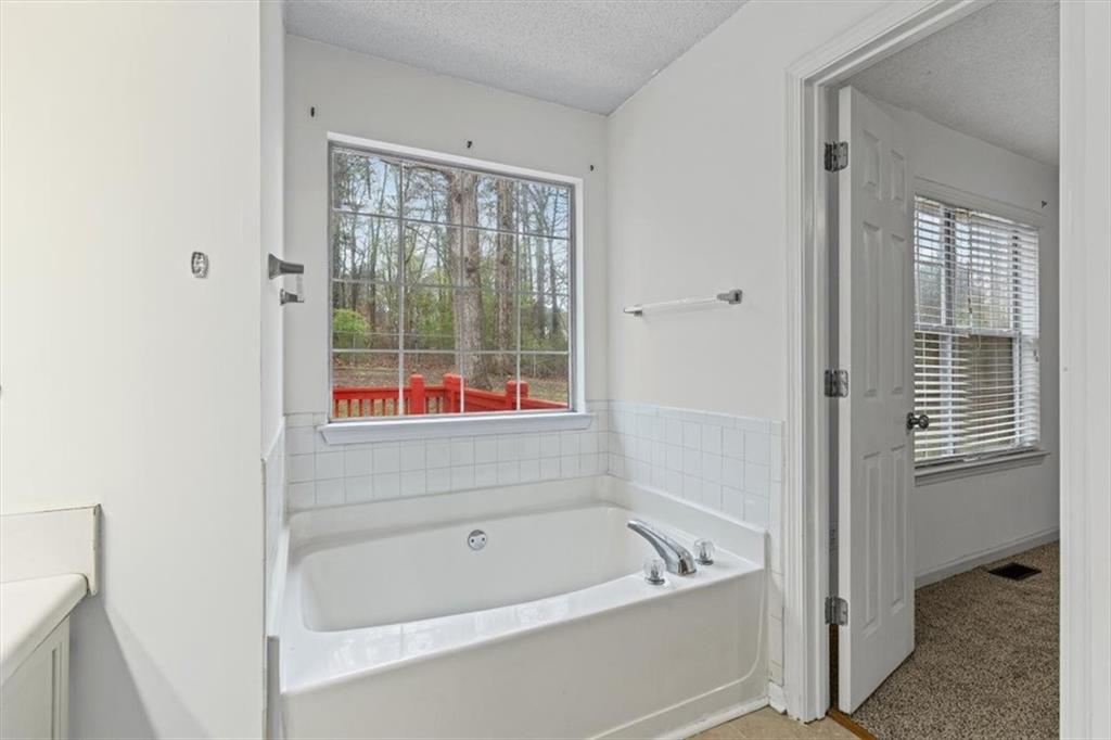 2242 Rocksram Court Buford, GA 30519 - Photo 30 of 52 a bathroom with a bathtub and a shower
