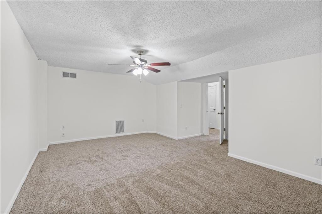 2242 Rocksram Court Buford, GA 30519 - Photo 34 of 52 a view of an empty room with a chandelier fan