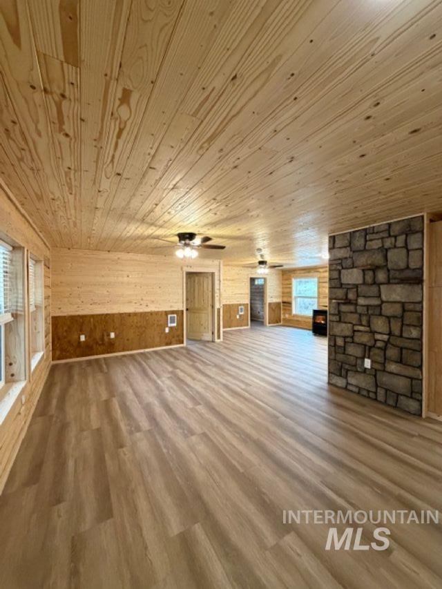 124 Windmill Lane Kooskia, ID 83539 - Photo 15 of 47 Unfurnished living room featuring wood walls, wood finished floors, wooden ceiling, and ceiling fan