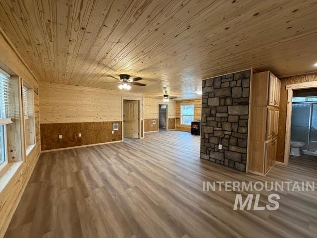 124 Windmill Lane Kooskia, ID 83539 - Photo 16 of 47 Unfurnished living room featuring wood walls, dark wood finished floors, wooden ceiling, and ceiling fan