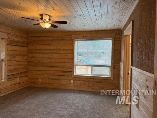 124 Windmill Lane Kooskia, ID 83539 - Photo 18 of 47 Spare room with carpet, a ceiling fan, and wooden walls