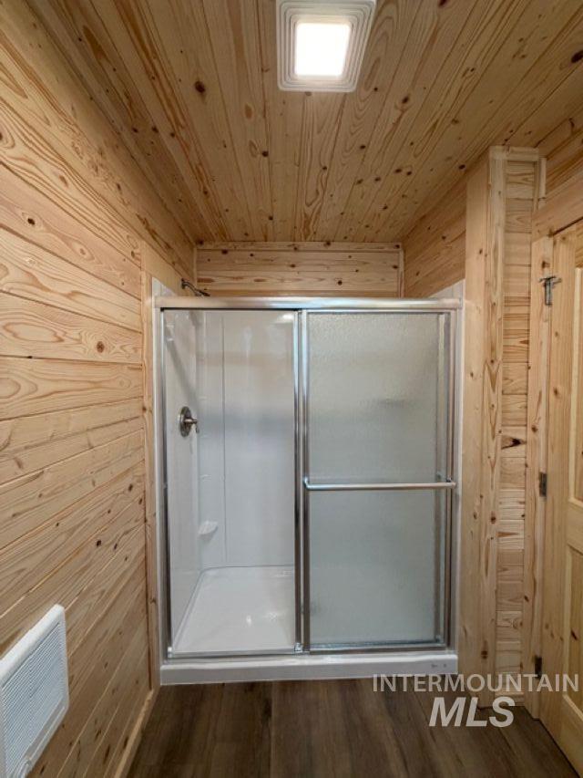 124 Windmill Lane Kooskia, ID 83539 - Photo 21 of 47 Full bathroom with wooden walls, a shower stall, dark wood-type flooring, and wood ceiling