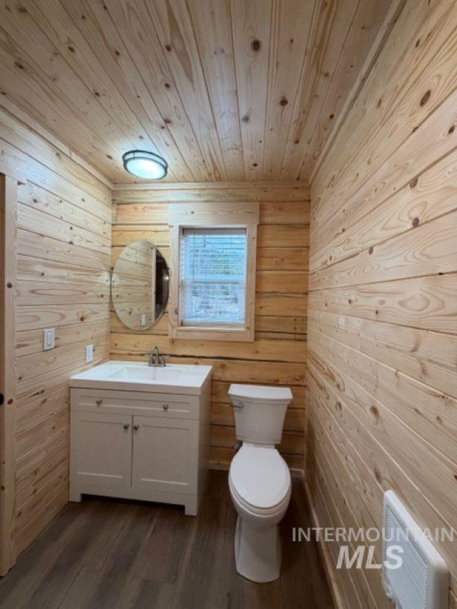 124 Windmill Lane Kooskia, ID 83539 - Photo 25 of 50 Bathroom with vanity, dark wood finished floors, and wooden walls