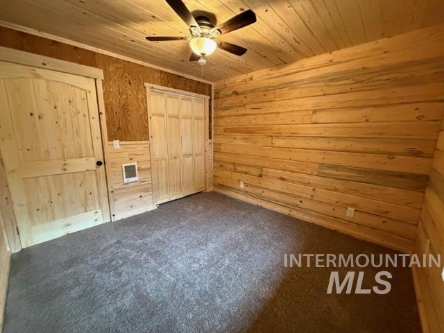 124 Windmill Lane Kooskia, ID 83539 - Photo 31 of 50 Unfurnished bedroom with carpet flooring, ceiling fan, wooden walls, a closet, and wood ceiling