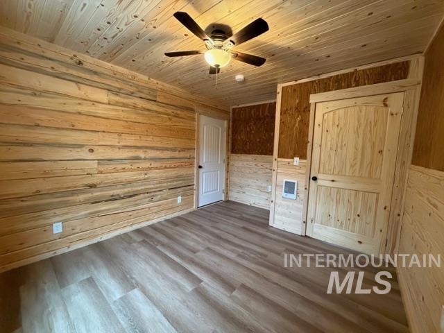 124 Windmill Lane Kooskia, ID 83539 - Photo 33 of 50 Unfurnished bedroom with wood walls, dark wood-type flooring, ceiling fan, and wood ceiling