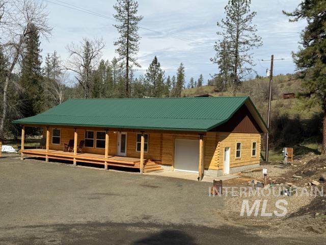 124 Windmill Lane Kooskia, ID 83539 - Photo 4 of 47 Log-style house featuring a metal roof, covered porch, driveway, and a garage