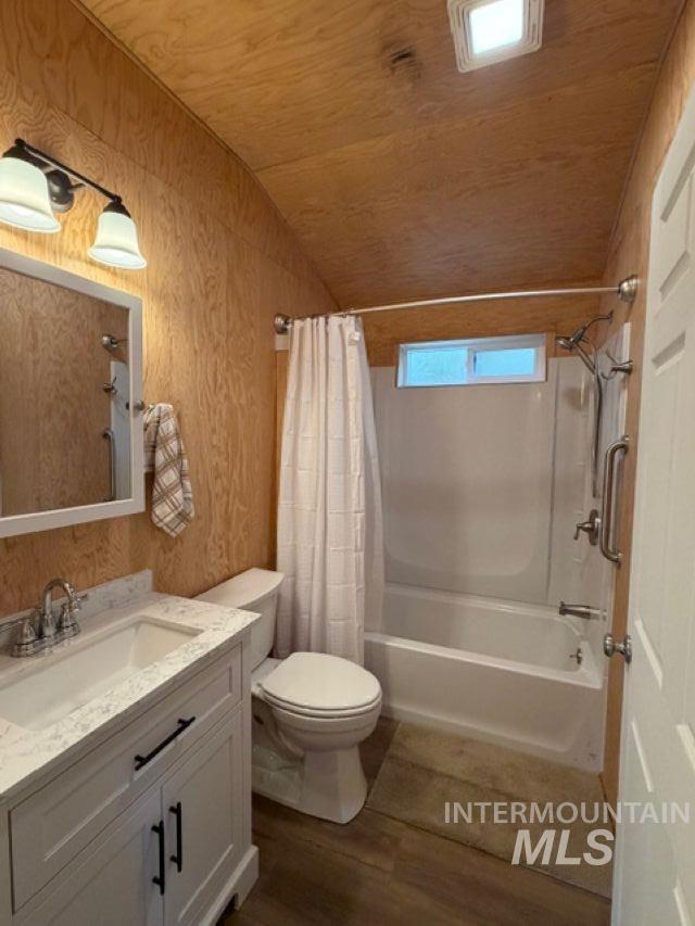 124 Windmill Lane Kooskia, ID 83539 - Photo 39 of 47 Full bathroom with vanity, vaulted ceiling, shower / bathtub combination with curtain, and dark wood finished floors