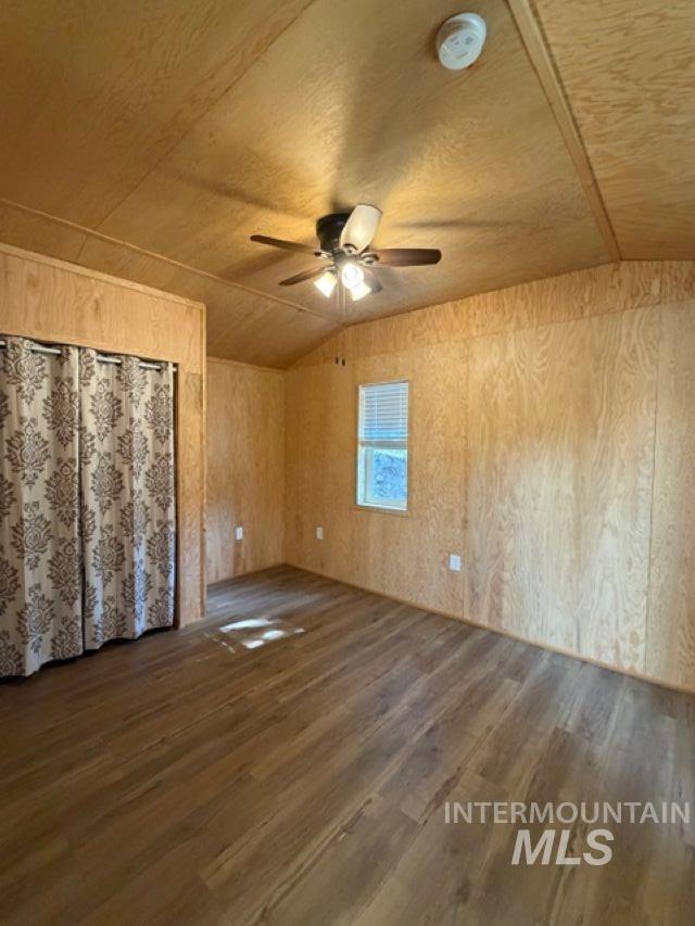 124 Windmill Lane Kooskia, ID 83539 - Photo 41 of 47 Spare room with vaulted ceiling, dark wood-type flooring, wooden walls, and a ceiling fan