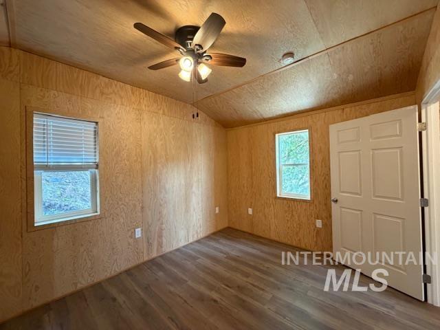 124 Windmill Lane Kooskia, ID 83539 - Photo 45 of 50 Unfurnished room with wooden walls, lofted ceiling, dark wood-type flooring, and a ceiling fan
