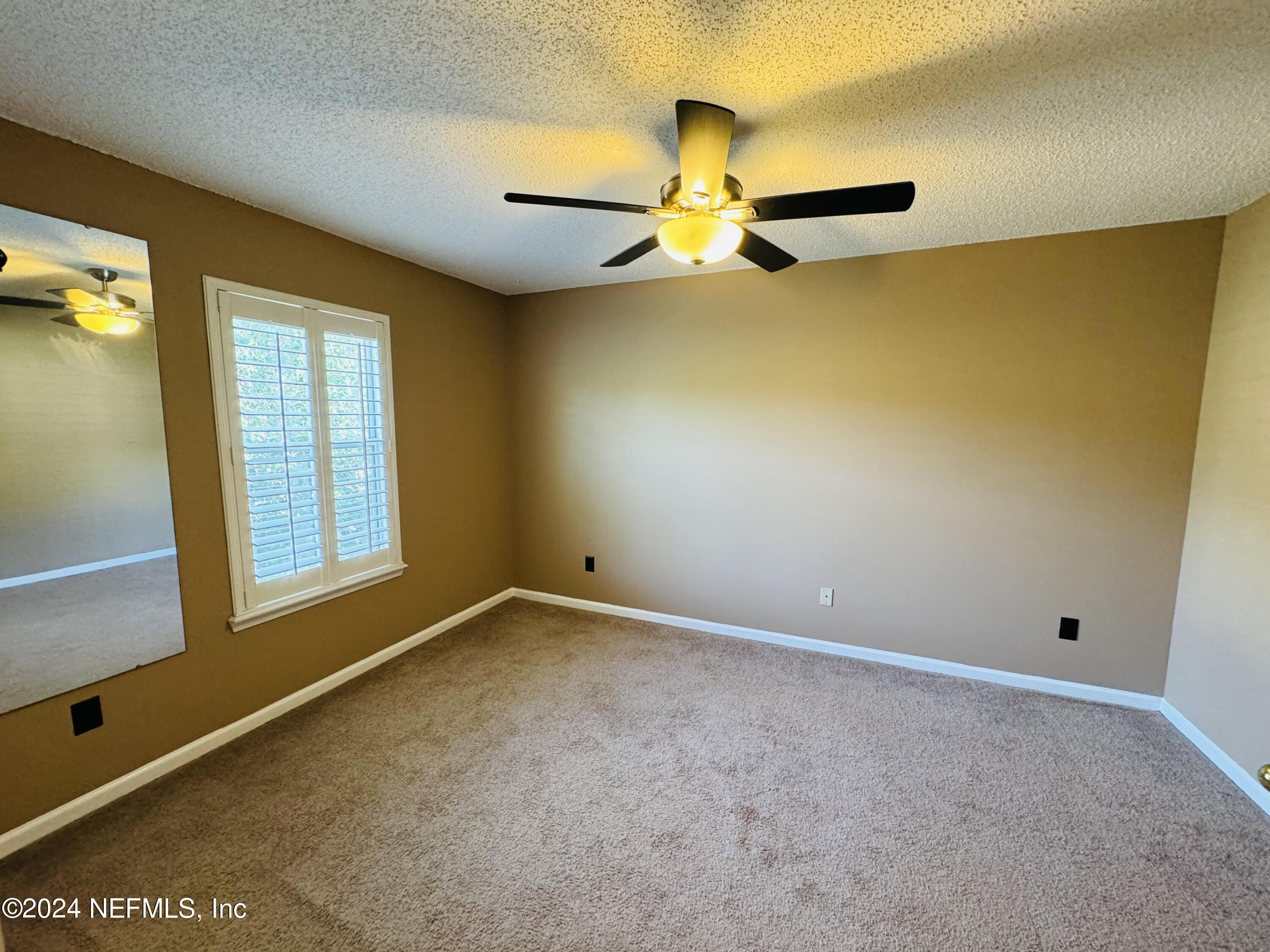 305 Blue Lake Road, Unit 2 St. Johns, FL 32259 - Photo 28 of 45 an empty room with a window and a ceiling fan