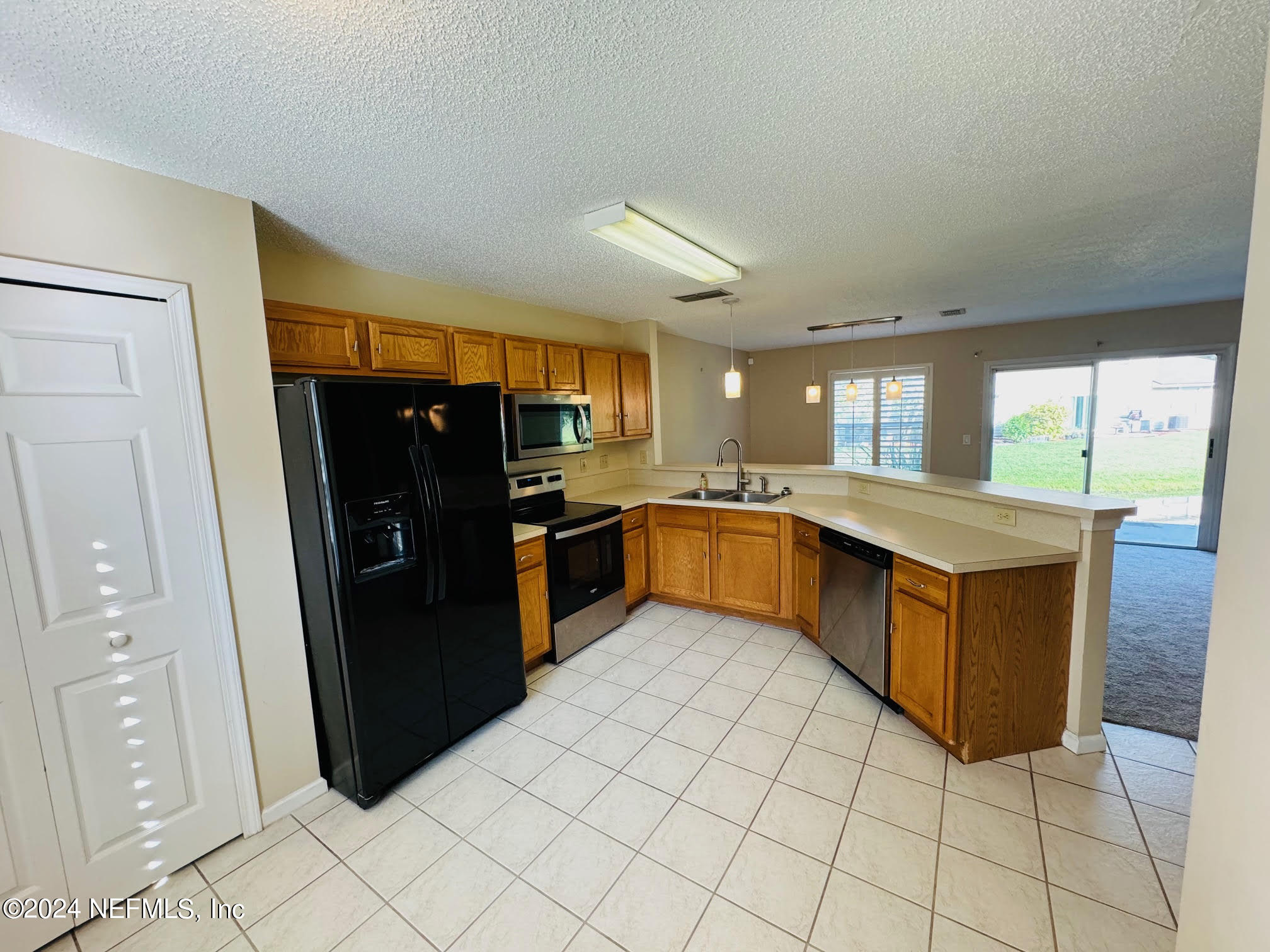 305 Blue Lake Road, Unit 2 St. Johns, FL 32259 - Photo 8 of 45 a large kitchen with stainless steel appliances kitchen island granite countertop a refrigerator and a sink
