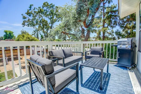a roof deck with couches and wooden floor