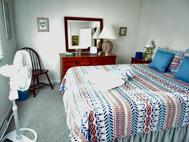 a bedroom with a bed and painting on the wall