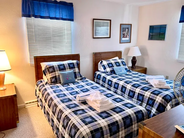 a bedroom with two beds and a lamp