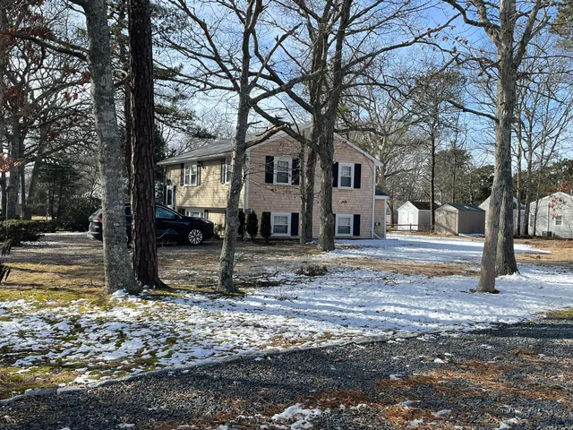 a view of a house with a yard covered in snow