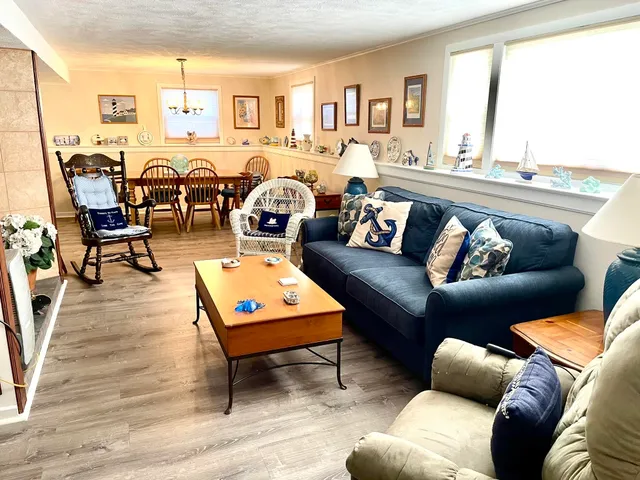 a living room with furniture wooden floor and a large window