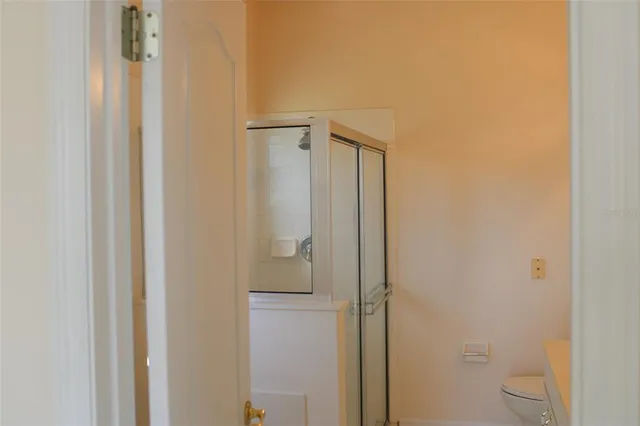 a bathroom with a granite countertop toilet and a shower