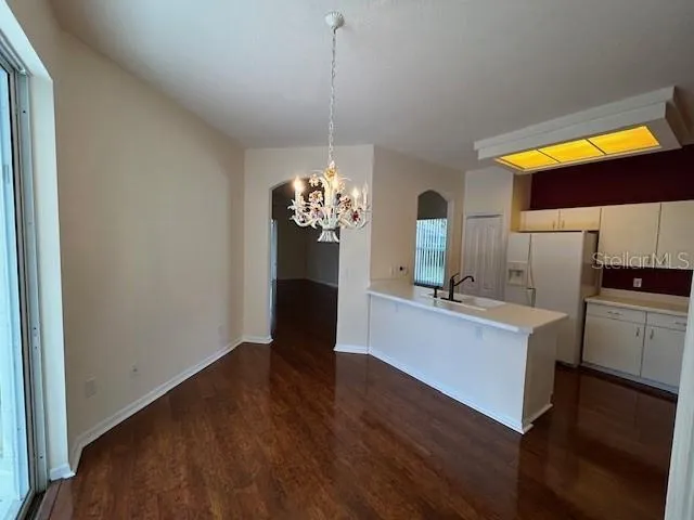 a view of kitchen with kitchen island wooden floor and stainless steel appliances