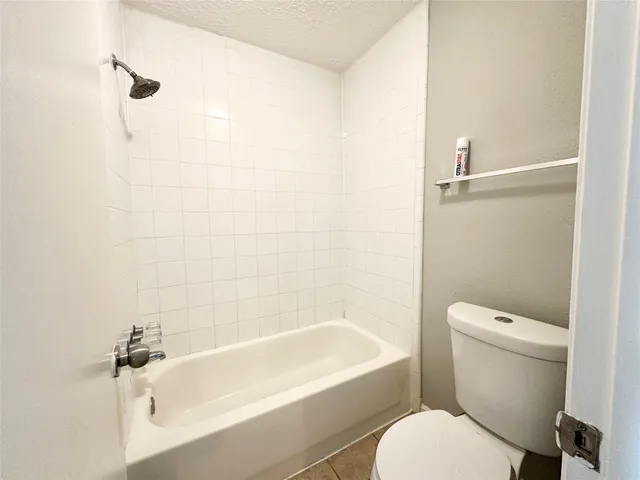 a white toilet sitting next to a bath tub