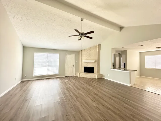 a view of empty room with wooden floor and ceiling fan