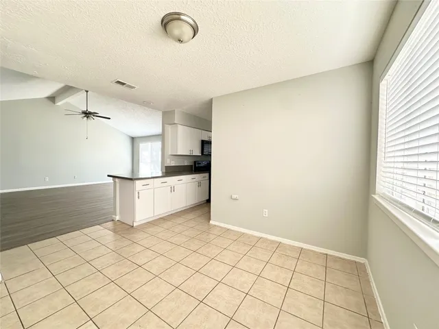 a view of a kitchen with white cabinets and a stove top oven