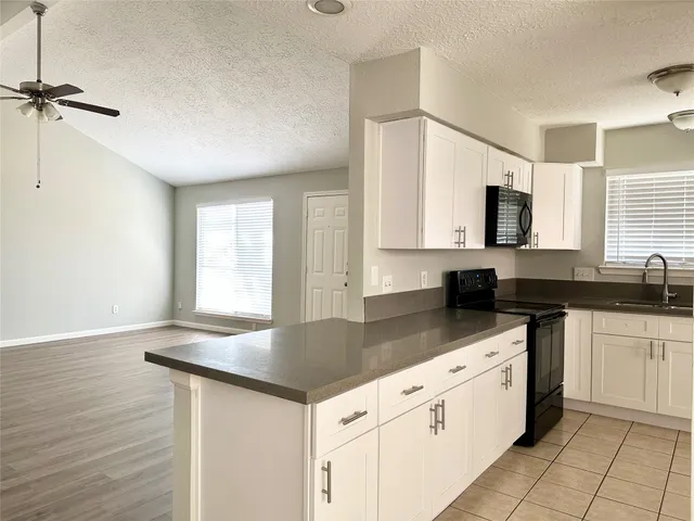 a kitchen with granite countertop a sink cabinets and window