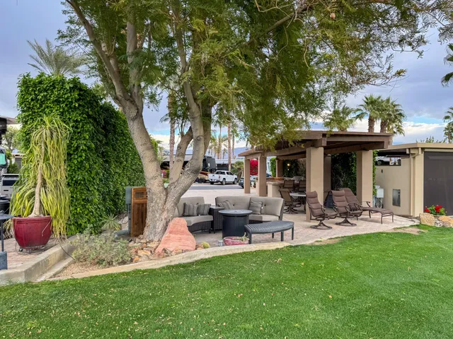 a front view of a house with garden and sitting area