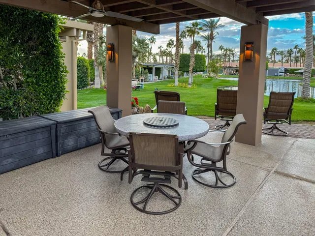 a view of a patio with a table chairs and a yard