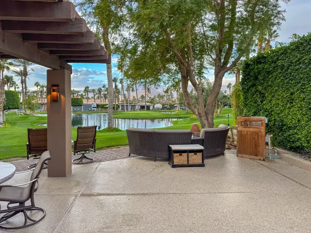a view of a patio with table and chairs potted plants and a palm tree