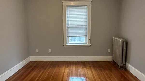 a view of a room with wooden floor and a window