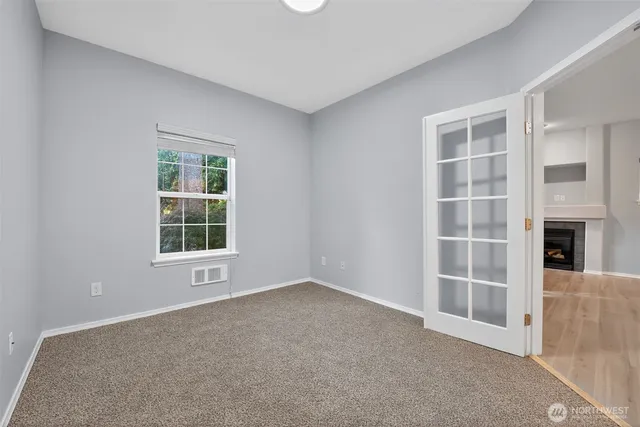an empty room with a fireplace and windows
