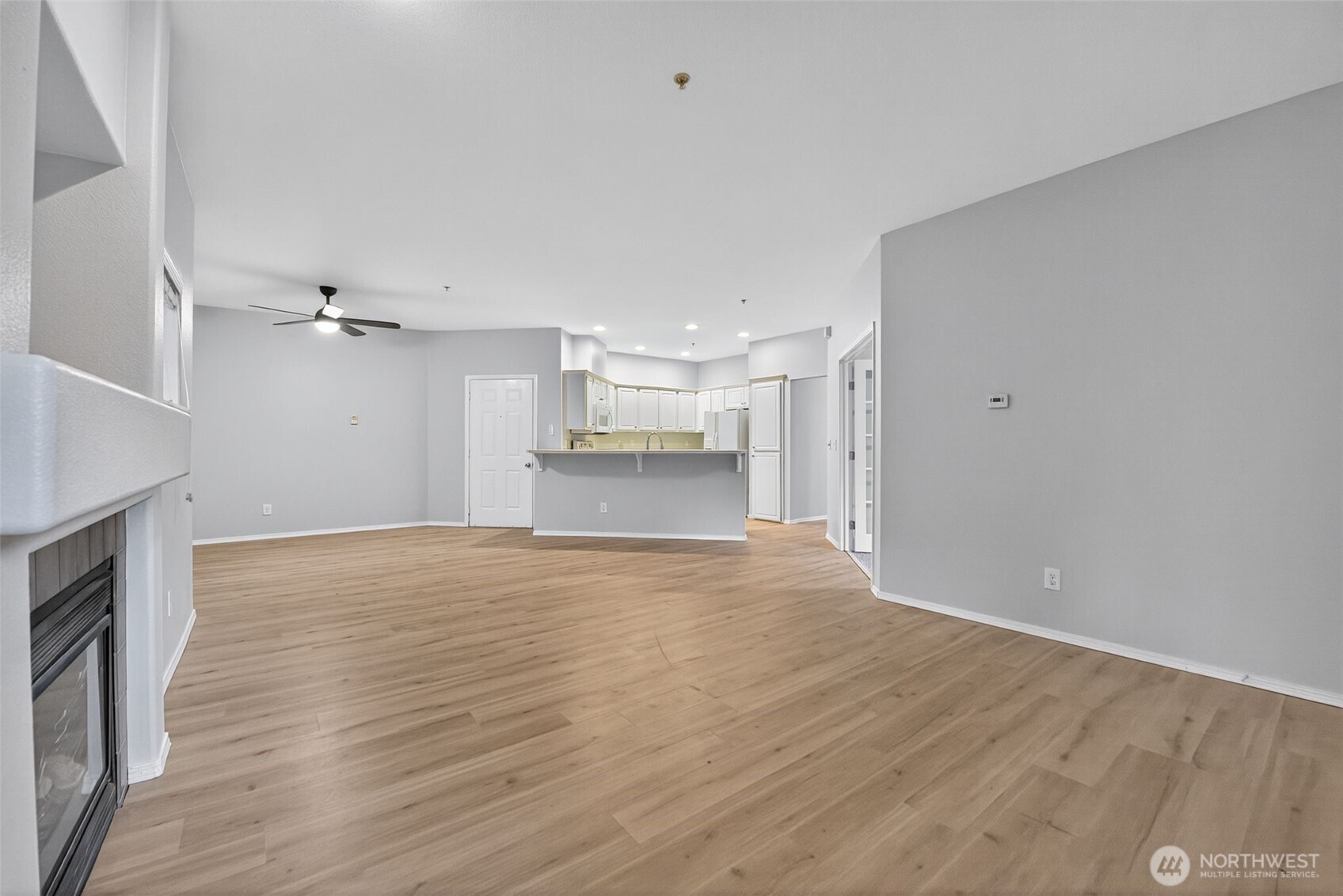1680 Kennedy Place, Unit A4 DuPont, WA 98327 - Photo 9 of 24 a view of empty room with wooden floor and kitchen