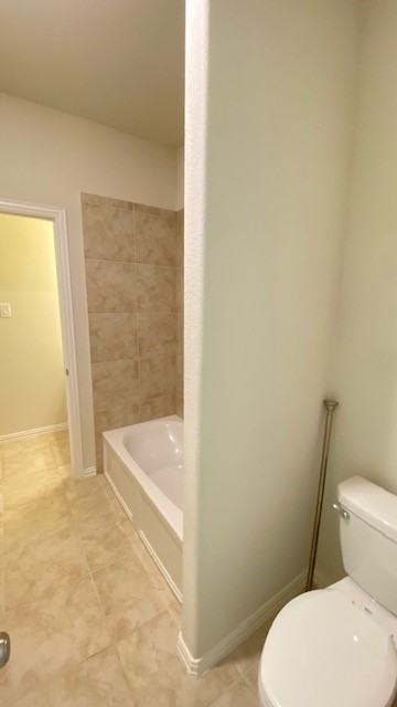 5002 Naples Grove Lane Rosharon, TX 77583 - Photo 12 of 38 Bright and clean bathroom featuring a tiled bathtub and shower combination, complemented by elegant flooring and a classic white toilet.