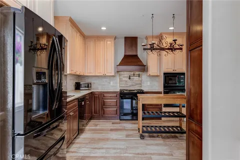 a kitchen with stainless steel appliances granite countertop a refrigerator a stove and a sink