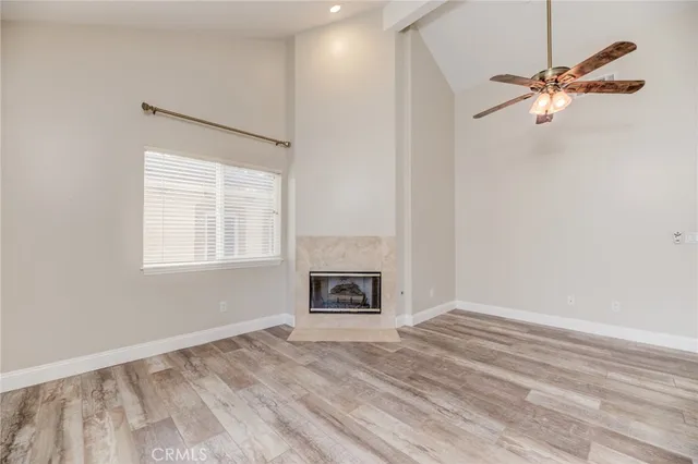 a view of an empty room with a fireplace and a window