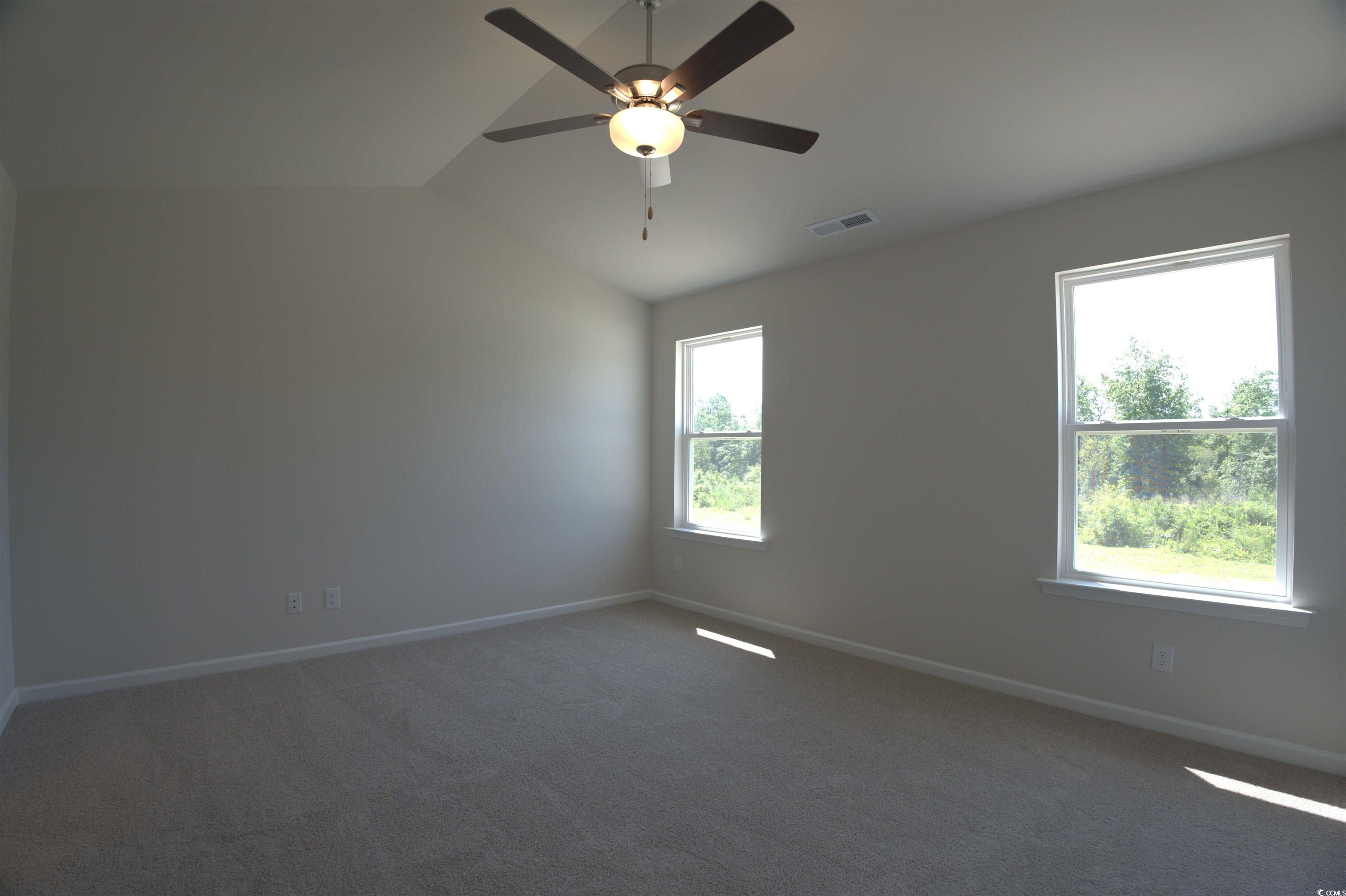 2654 Tansy Road Loris, SC 29569 - Photo 7 of 10 Spare room with vaulted ceiling, dark colored carpet, and ceiling fan