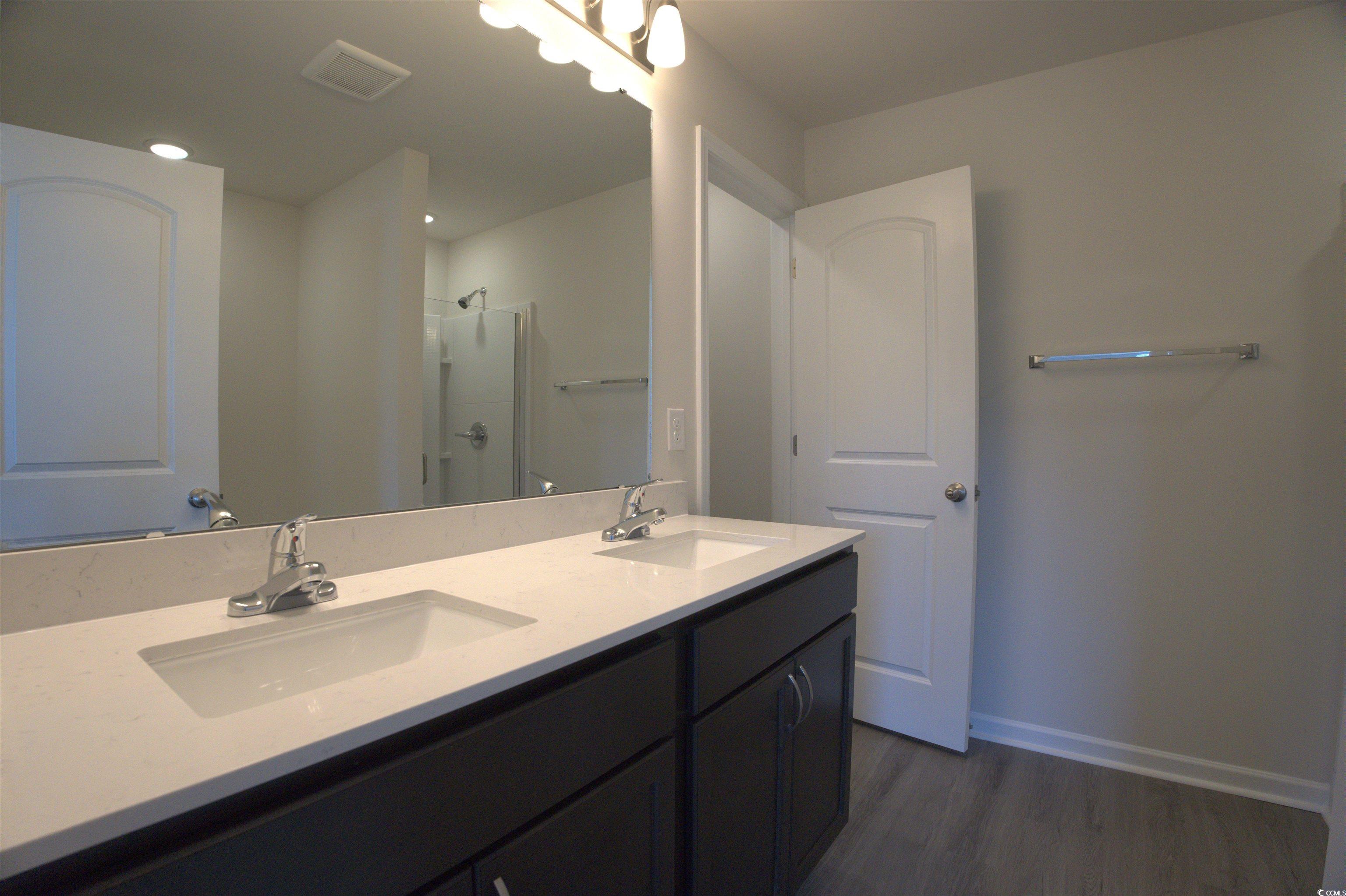 2654 Tansy Road Loris, SC 29569 - Photo 9 of 10 Full bathroom featuring double vanity, a stall shower, and dark wood finished floors